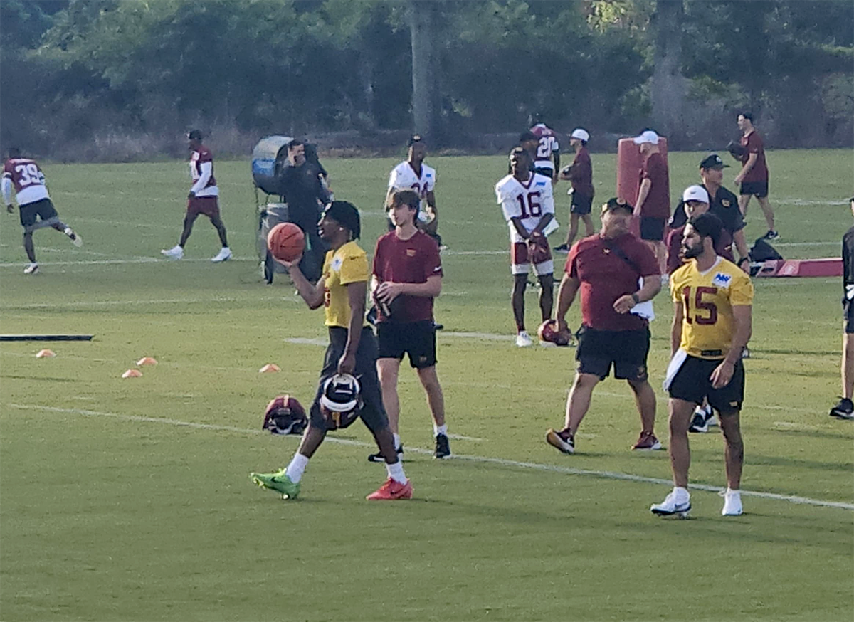Jayden Daniels leads the Commanders on to the practice field.